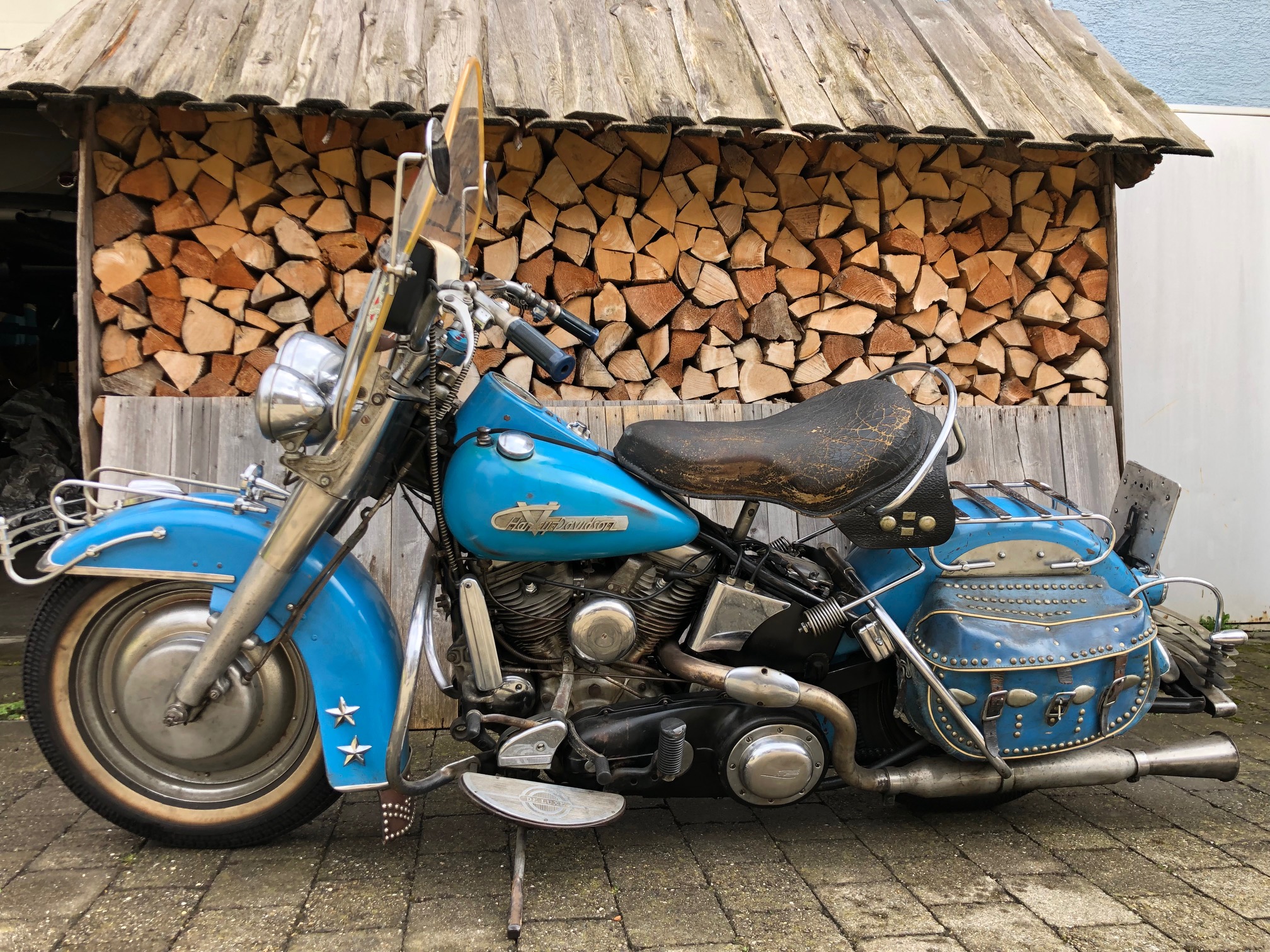 Türkisblaue Panhead mit Windschutzscheibe, Nietensatteltaschen und Sternen am Vorderschutzblech